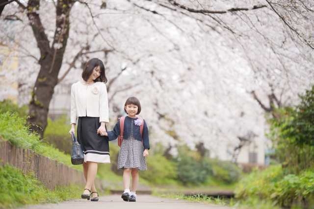桜のしたを並んで歩く親子
